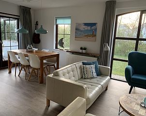 La Guitarra Texel, eetruimte met grote tafel en uitzicht op de tuin in De Cocksdorp.