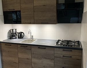 Moderne keuken in La Guitarra vakantiehuis De Cocksdorp Texel met houten kastjes.