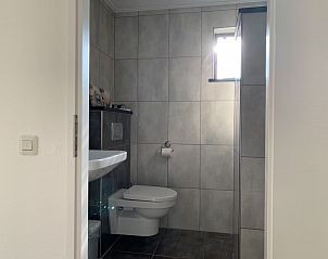 Moderne badkamer in La Guitarra vakantiehuis De Cocksdorp Texel met tegelafwerking.