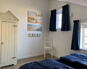 La Guitarra De Cocksdorp Texel, gezellige zithoek op veranda met glazen tafel.