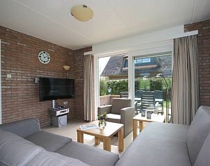 Lichte woonkamer van 6 Persoons gezellige vakantiebungalow in De Cocksdorp Texel met uitzicht op het terras.