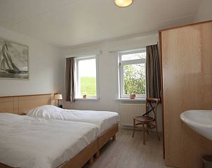 Comfortabele slaapkamer in 6 Persoons gezellige vakantiebungalow De Cocksdorp Texel met natuurlijk licht.