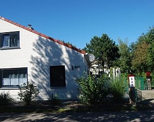 Voorzijde van De Krim 641 vakantiehuis in De Cocksdorp Texel omgeven door groen.