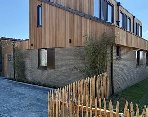 Zijkant van Vakantiehuis aan de golfbaan, De Cocksdorp Texel, Waddeneilanden, met houten en bakstenen elementen.