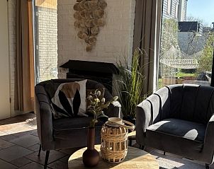 Luxe zithoek met fauteuils in Vakantiehuis aan de golfbaan, De Cocksdorp Texel, Waddeneilanden, met decoratieve elementen.