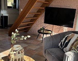 Houten trap in de woonkamer van Vakantiehuis aan de golfbaan, De Cocksdorp Texel, Waddeneilanden, met moderne inrichting.