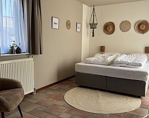 Slaapkamer in Vakantiehuis aan de golfbaan, De Cocksdorp Texel, Waddeneilanden, met tweepersoonsbed en decoraties.
