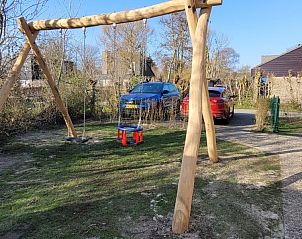 Speelterrein met schommel bij Het Eiland Gevoel, een vakantiehuis in De Cocksdorp op Texel, omringd door natuur en rust.