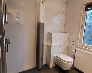 Moderne badkamer in Het Eiland Gevoel, vakantiehuis in De Cocksdorp, Texel, met strakke douche en toilet, ideaal voor een ontspannen verblijf.