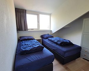Sfeervolle slaapkamer in vakantiehuis Het Eiland Gevoel, De Cocksdorp, Texel met comfortabele bedden en veel natuurlijk licht.