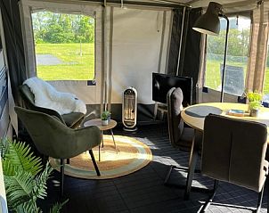 Lichte en ruime zithoek in Caravan Joanneshoeve, De Cocksdorp Texel, met uitzicht op de groene natuur van de Waddeneilanden.