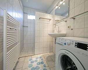 Modernes Badezimmer mit begehbarer Dusche und Waschmaschine im Ferienhaus Slufterhoek 044, De Cocksdorp Texel, fr zustzlichen Komfort.