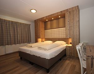 Attractive bedroom in Villa De Witte Hoek 138 conservatory, De Cocksdorp Texel with wooden details.