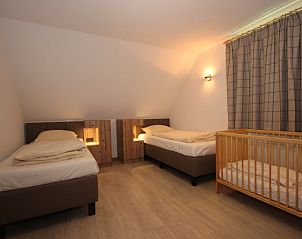 Children's room in Villa De Witte Hoek 138 conservatory, De Cocksdorp Texel with crib and two beds.