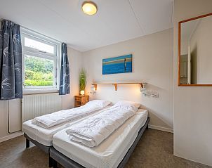 Schlafzimmer im Ferienhaus Slufterhoek 150, De Cocksdorp Texel, mit Doppelbett und Gartenblick.