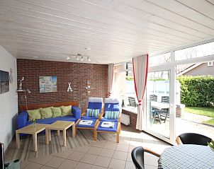 Gemtliches Wohnzimmer des Ferienhauses Slufterhoek 122 in De Cocksdorp, Texel, mit Blick auf die Terrasse und den Garten.