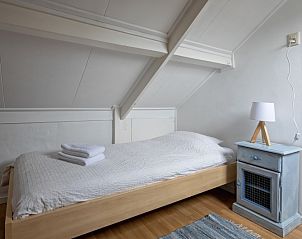 Rustieke slaapkamer met houten meubels in Kikkertstraat 065, vakantiehuis De Cocksdorp Texel voor een rustige nacht.