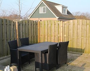 Gemtliche Terrasse am Ferienhaus Onder de vuurtoren 115, De Cocksdorp, Texel fr Mahlzeiten im Freien.