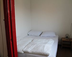 Slaapkamer in Onder de vuurtoren 113 vakantiehuis De Cocksdorp Texel met comfortabel bed en serene sfeer voor rust.