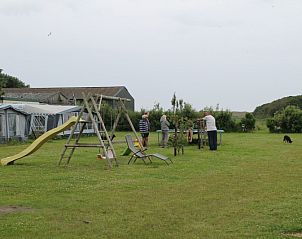 Ruime buitenruimte bij Onder de vuurtoren 113 vakantiehuis De Cocksdorp Texel met speeltoestellen en natuur.