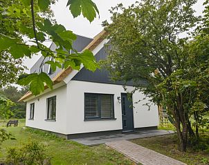 Eingang zum Ferienhaus De Postschipper in De Cocksdorp, Texel, umgeben von Grnanlagen.