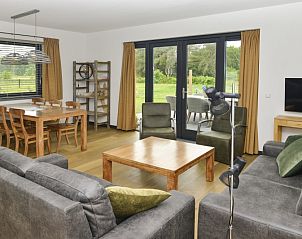 Gemtliche Sitzecke im Ferienhaus De Postschipper auf Texel mit groen Fenstern.