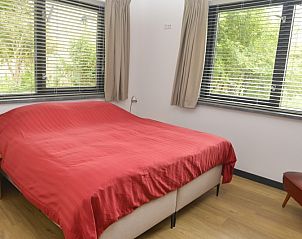 Schlafzimmer mit Doppelbett im Ferienhaus De Postschipper auf Texel mit Tageslicht.