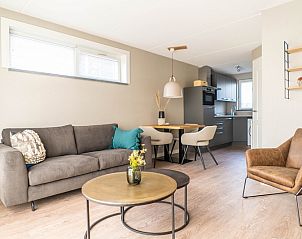 Cozy sitting area and kitchen in vacation home Type D Kikkertstraat, De Cocksdorp, Texel, for a relaxing stay.