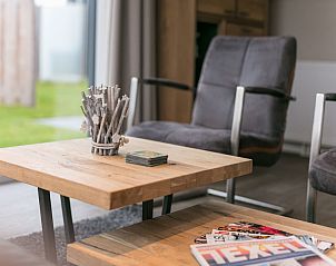 Cozy living room of Chalet 08 Newport in De Cocksdorp Texel with wooden table and chairs.