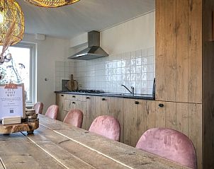 Dining area with wooden table in Holiday home De Vuurtoren, Texel, Wadden Islands.