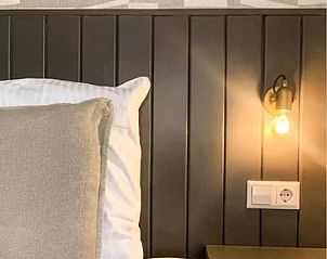 Attractive bedroom in Holiday Home Hogezandskil, De Cocksdorp, Texel with modern lighting and comfortable bed.