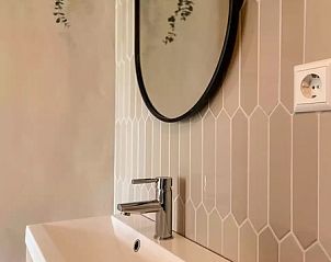Modern bathroom in Holiday home Hogezandskil, De Cocksdorp, Texel with elegant washbasin cabinet and mirror.