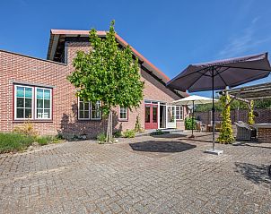 Ruim terras bij Vakantiehuis Paal 86, De Cocksdorp, Texel, met parasol en zitplekken.