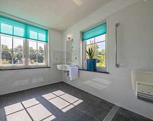 Lichtovergoten badkamer in Vakantiehuis Paal 86, De Cocksdorp, Texel, met grote ramen.