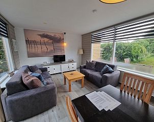 Lichte woonkamer van Bungalow 174 - Zilt Zand op Texel met uitzicht op de tuin bij Bungalowpark Tamarisk.