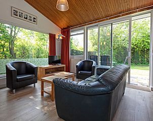 Helles Wohnzimmer des Ferienhauses Slufterduin 128 in De Cocksdorp, Texel mit Gartenblick.