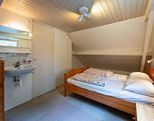 Attractive bedroom with wooden interior in Holiday home Slufterduin 108, De Cocksdorp Texel, for a relaxing stay.