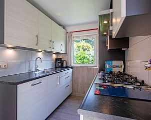 Fully equipped kitchen in Holiday home Slufterhoek 174, De Cocksdorp, Texel, with modern appliances and garden views.