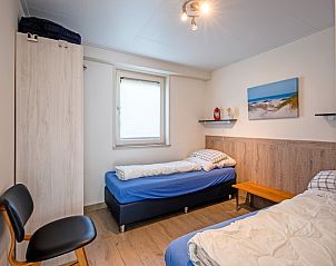 Comfortable bedroom with two beds in Holiday home Slufterhoek 174, De Cocksdorp, Texel, for a good night's sleep.