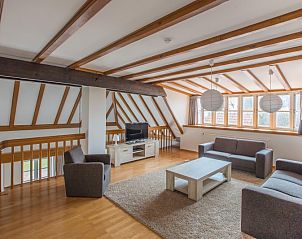 Gemtliches Wohnzimmer des Ferienhauses Typ W in De Cocksdorp Texel, mit Holzbalken und viel Tageslicht auf den Watteninseln.