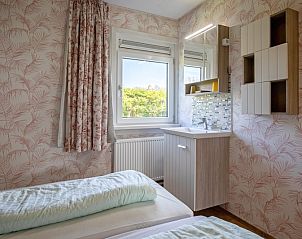 Kompaktes Schlafzimmer im Ferienhaus Slufterhoek 072, De Cocksdorp, Texel mit Waschbecken und frischem Look.