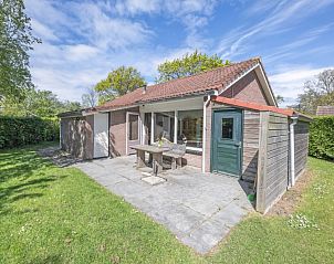 Auenbereich des Ferienhauses Slufterhoek 180 in De Cocksdorp, Texel, mit sonniger Terrasse und grnem Garten.
