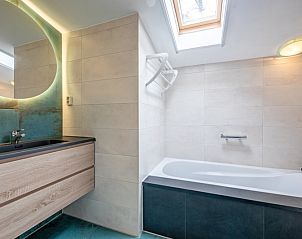 Stilvolles Badezimmer mit Waschbecken und Badewanne im Ferienhaus Slufterhoek 180, De Cocksdorp, Texel.