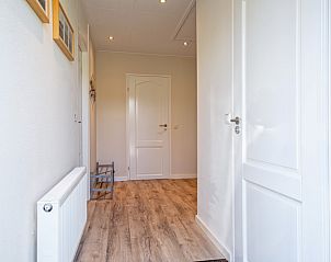 Bright hallway in Holiday home Slufterhoek 102, De Cocksdorp, Texel with wooden floor and access to several rooms.