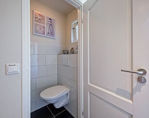 Stylish bathroom in Holiday home Slufterhoek 102, De Cocksdorp, Texel with modern toilet and sleek white tiles.