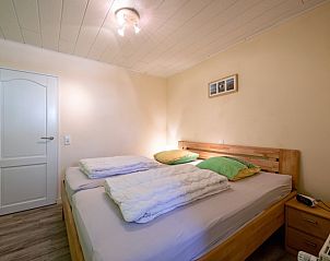 Bedroom in Holiday home Slufterhoek 102, De Cocksdorp, Texel with double bed and warm lighting for a soothing atmosphere.