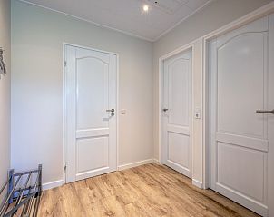 Spacious hall in Holiday home Slufterhoek 102, De Cocksdorp, Texel with several doors to bedrooms and bathroom.