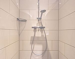 Modern shower in Holiday home Slufterhoek 102, De Cocksdorp, Texel with sleek shower head and white wall tiles.