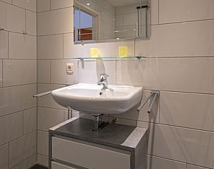 Functional sink in Holiday home Slufterhoek 102, De Cocksdorp, Texel with mirror cabinet and sleek finish.