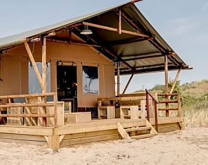 Cozy interior of Sluftervallei safari tent on Texel with wooden furnishings.